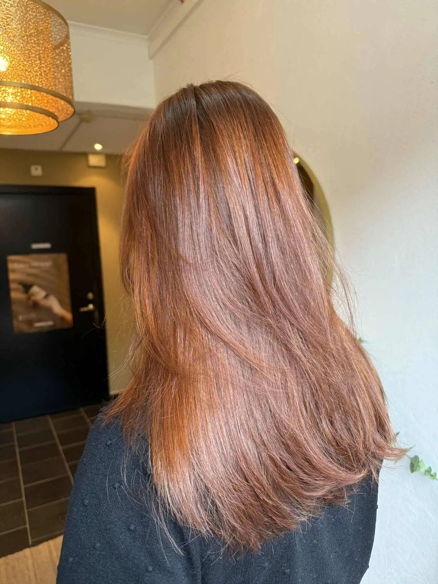 Glödande kopparrött hår med jämn färg och klippning som framhäver formen.